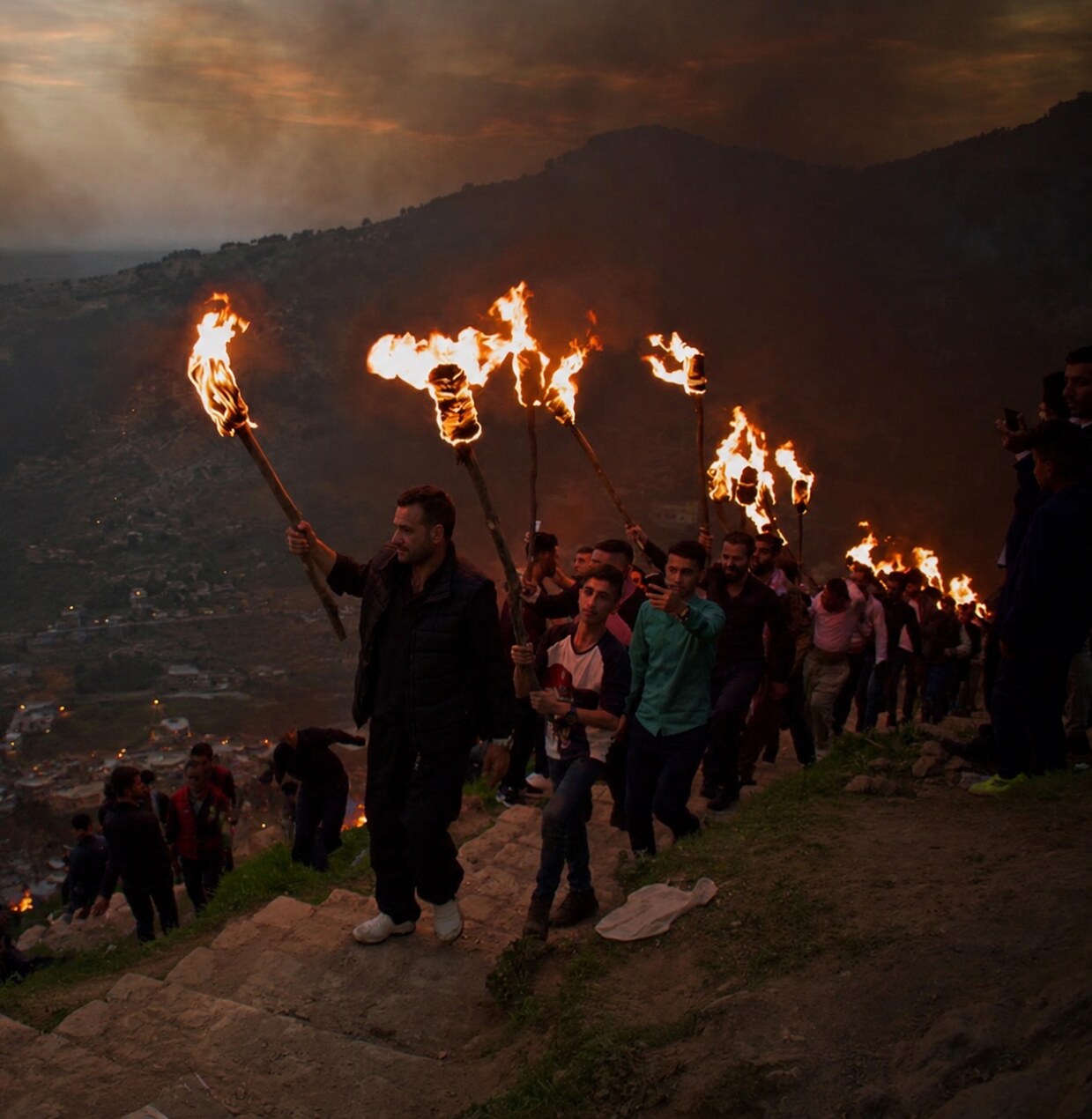 Crowds carrying flaming torches at a Newroz night celebration